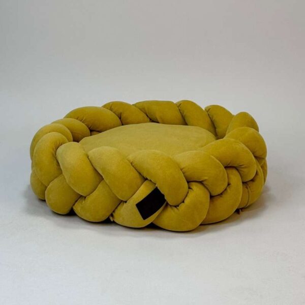 Round braided mustard yellow pet bed with soft cushion and woven edges.