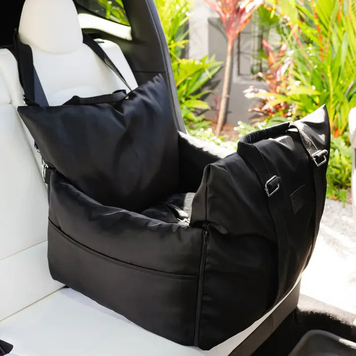 Black premium pet car seat with high sides and adjustable straps installed on a white car seat.