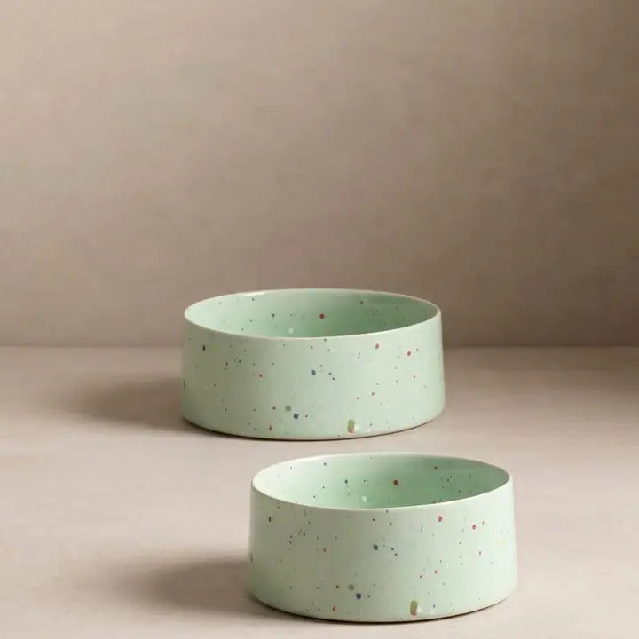 Set of two green ceramic pet bowls with multicolored speckled pattern, 16.5 cm diameter.