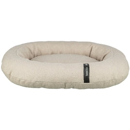 Oval cream dog bed with soft padded edges and fabric tag on front side.