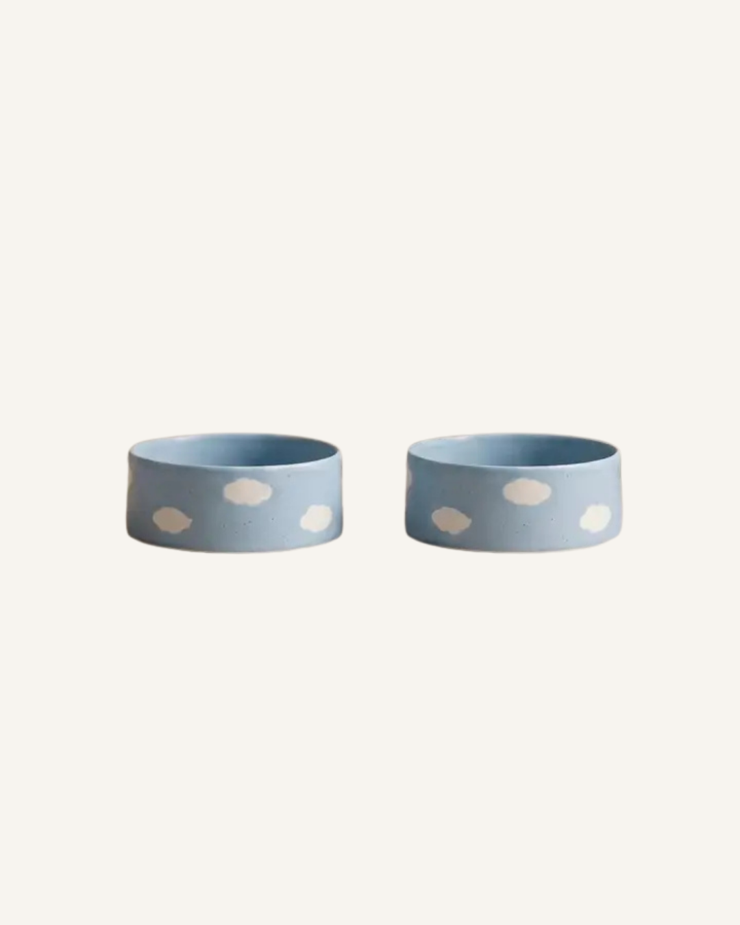 Pair of blue-gray ceramic pet bowls with white cloud-shaped spots and rounded sides.