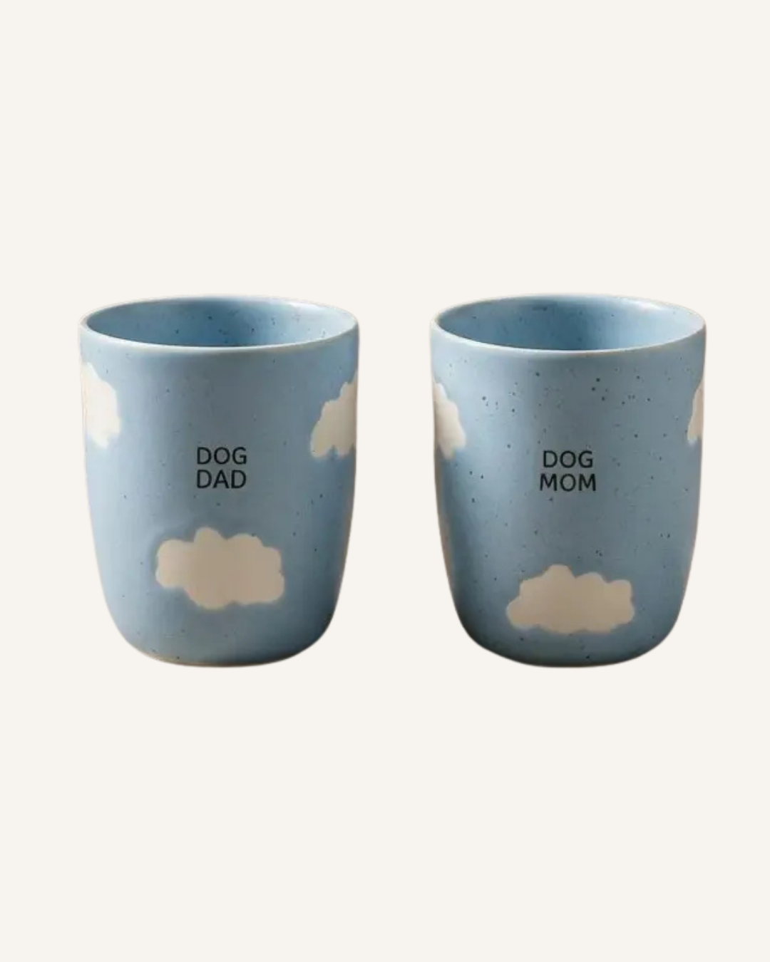 Set of two blue ceramic cups with cream cloud details, labeled “Dog Dad” and “Dog Mom.”.