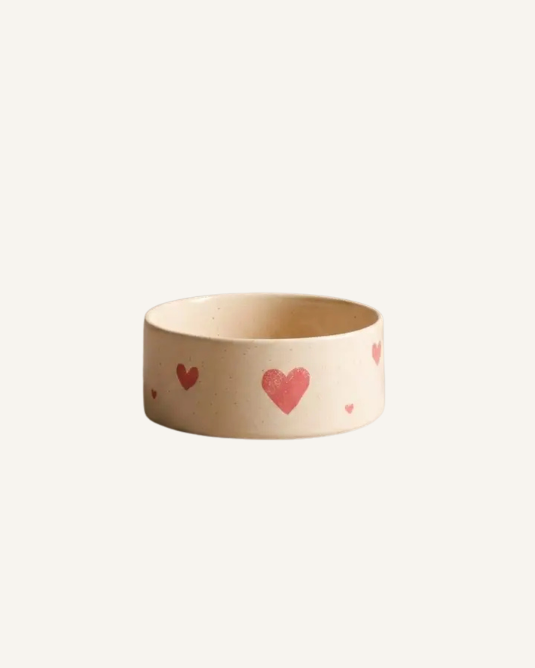 Cream ceramic pet bowl decorated with scattered red hearts and a glossy finish.