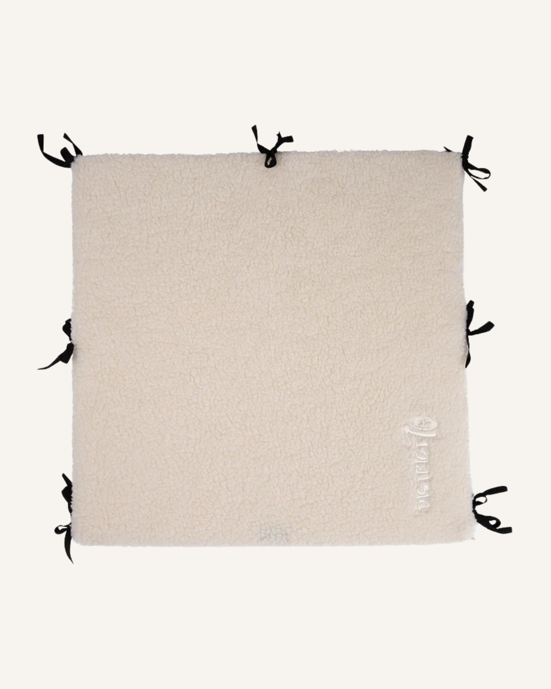 Beige soft sherpa fabric bench divider with black tie straps and subtle embroidered logo.
