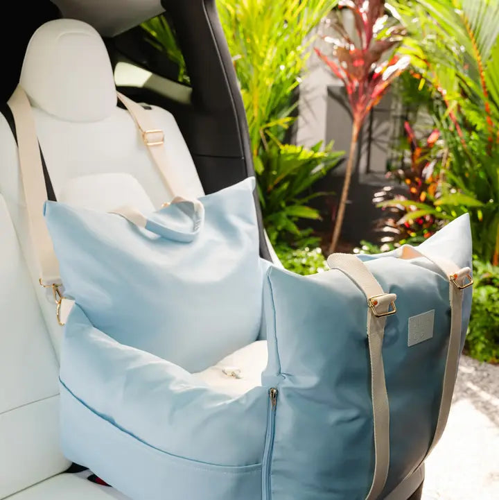 Light blue Lila Co premium pet car seat with adjustable straps and padded sides inside a car seat.