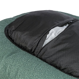 Oval dark green dog bed with removable black textured cover partially unzipped showing white interior lining.